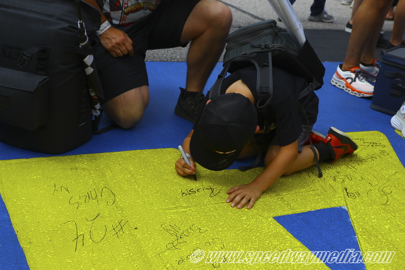 a young fan signing his name to the start finsih line.jpg