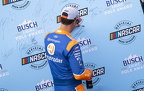 Joey Logano signs his name to the pole banner