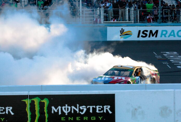 kyle-busch-donuts-ism Kyle Busch celebrates with donuts and tire smoke in front of the fans at the new start-finish line at ISM Raceway after winning the Can-Am 500. Photo by Rachel Schuoler for Speedway Media.