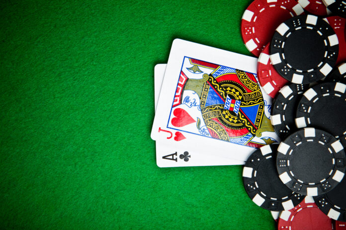 Black and red poker chips with cards in the background