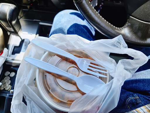 High Angle View of Food in Bowl in Car With Plastic Fork and Spoon on Lid