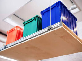 Overhead garage storage lift holding colorful plastic containers