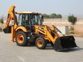 Yellow ACE backhoe loader parked on a paved lot