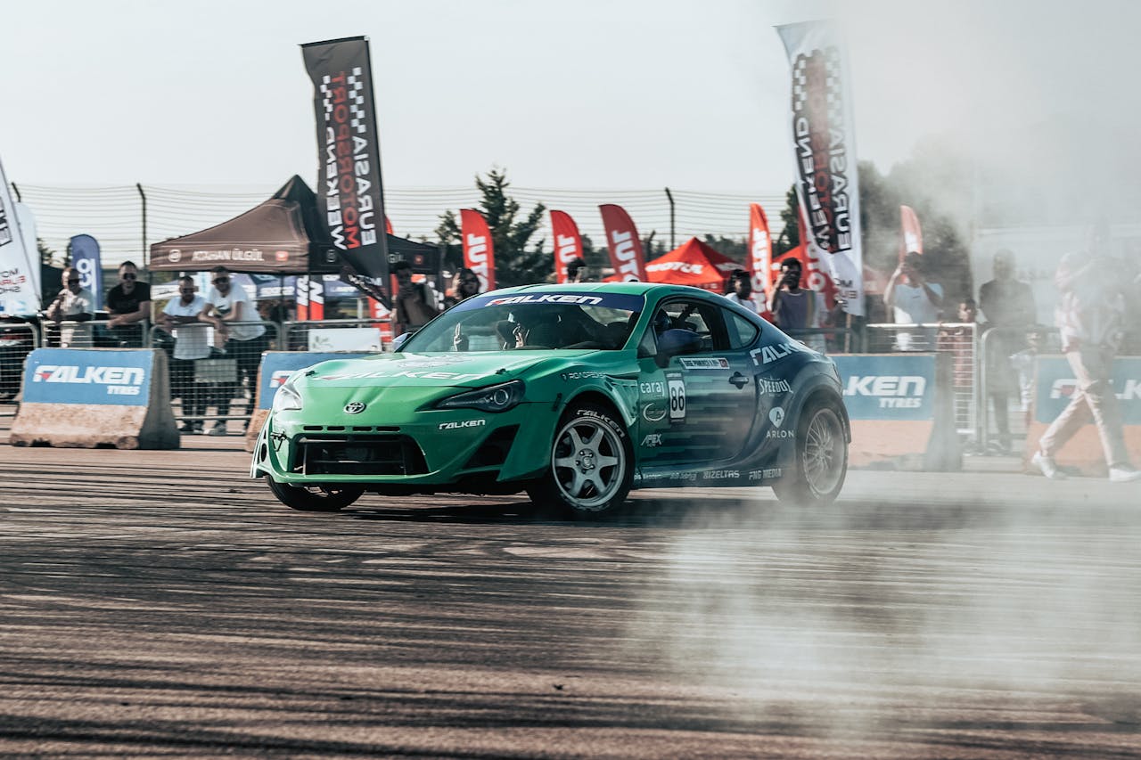3 Clever Sign Ideas for Racing Events Green Falken drift car kicking up smoke on racing track